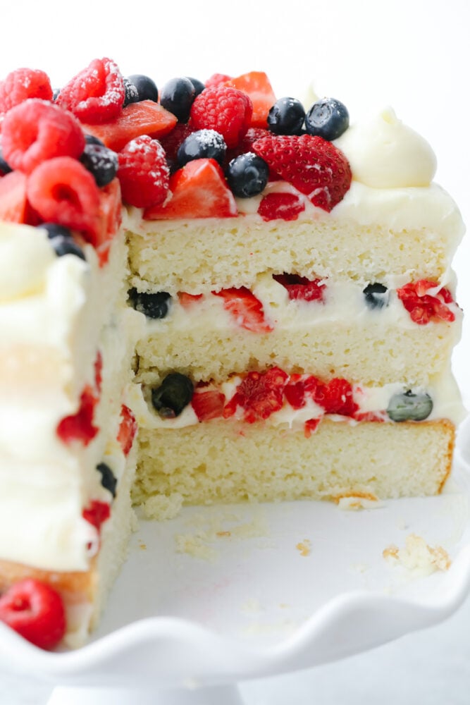 Showcase fresh summer berries with a supremely moist sponge cake and fluffy Chantilly cream! This beautiful Chantilly Berry Cake is a light, airy treat that is bound to impress! Piece cut out of Chantilly Berry Cake.