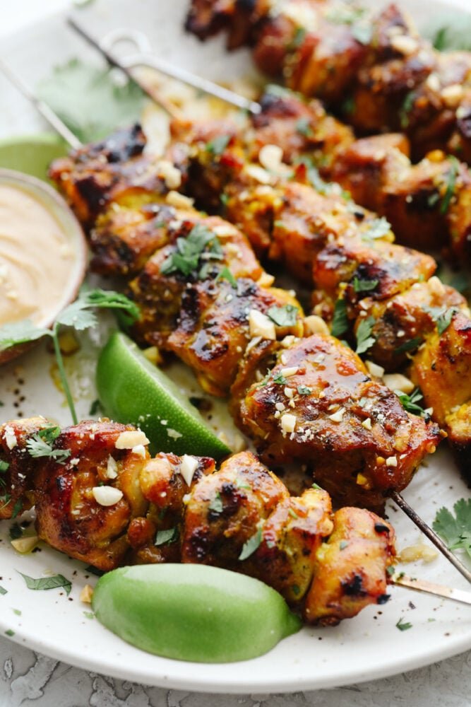 Chicken Satay is juicy, tangy, and absolutely divine. Marinated and then grilled to perfection serve these with a savory peanut sauce that is positively addicting. Chicken on skewers grilled with chopped peanuts for garnish.