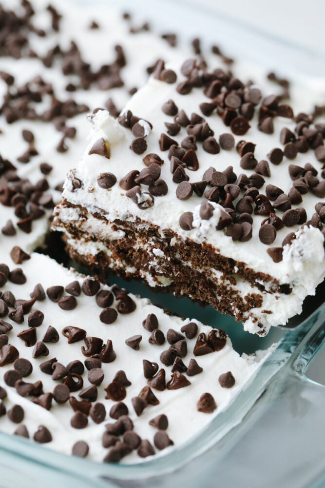 Chocolate Icebox Cake is an easy, and decadent chocolate lover's dream dessert. Made from simple ingredients and a bit of time, this no-bake cake is going to be a huge summertime hit! Scooping out a piece of cake.