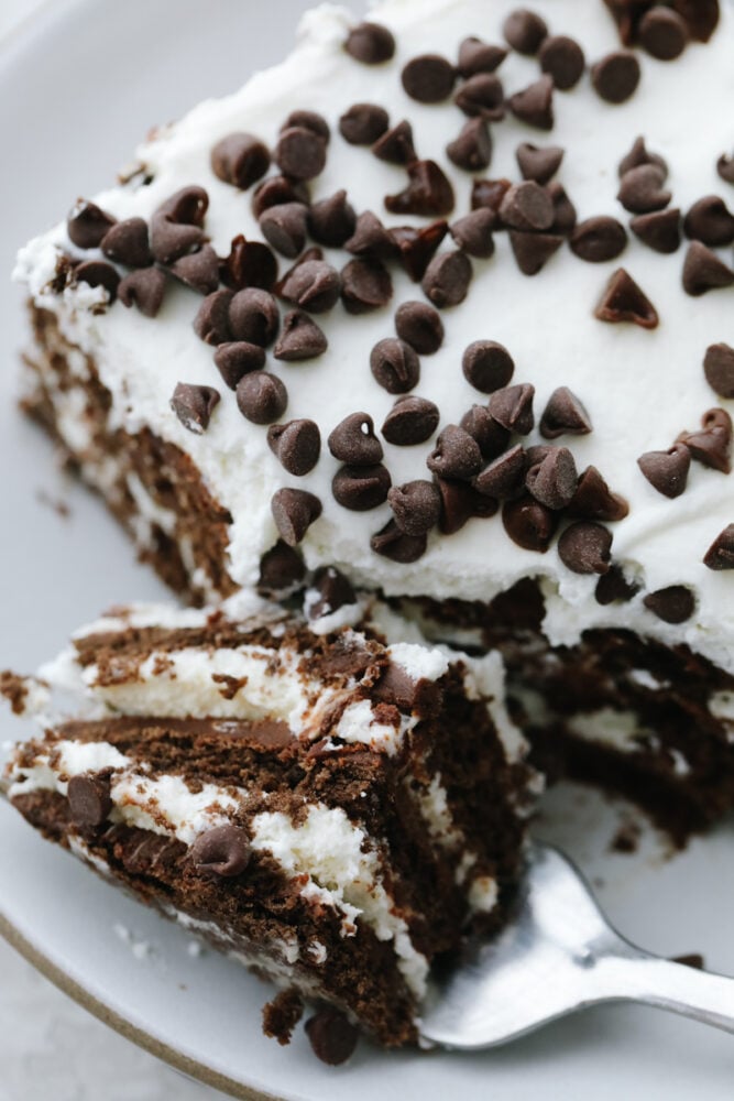 Chocolate Icebox Cake is an easy, and decadent chocolate lover's dream dessert. Made from simple ingredients and a bit of time, this no-bake cake is going to be a huge summertime hit! A slice of chocolate icebox cake cut with a fork.