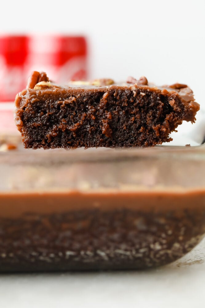 Coca Cola cake is an easy-to-make chocolate cake, topped with pecans and ooey-gooey chocolate frosting. It is so easy and absolutely delicious, you are going to love this cake and its subtle soda flavor! A slice of Coca-Cola cake.