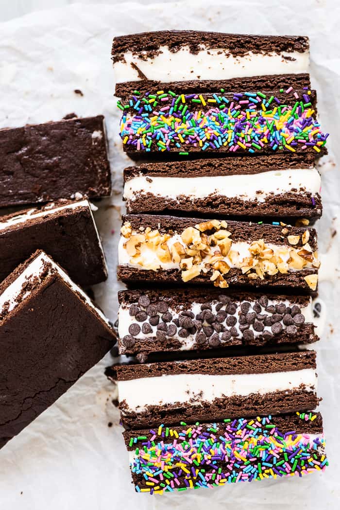 This homemade ice cream sandwich recipe is the ultimate summer treat. They're made with your favorite ice cream that's sandwiched between a brownie-like crust that stays soft even when frozen. Make a big batch and enjoy them all summer long! Ice cream sandwiches lined up in a row.