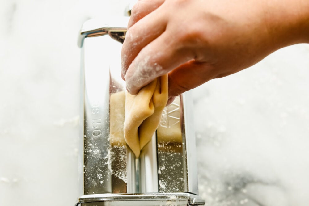 Homemade pasta is a labor of love but it is totally worth the extra work. This pasta is simple and easy, it just takes a bit of time Feeding the folded pasta into the pasta maker.