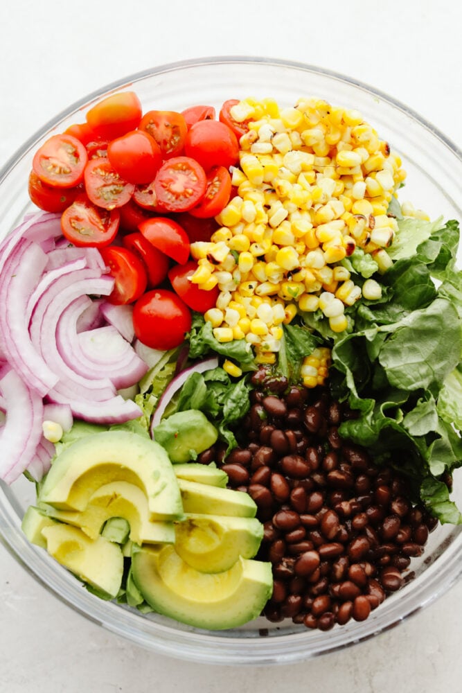 This easy grilled shrimp salad recipe is the perfect solution to your summer dinner needs! Itโs healthy, quick, and full of grilled chipotle flavor. A variety of vegetables and beans ready to be mixed.