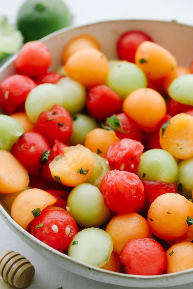 I don't know about you but nothing hits the spot more on a hot summer day than fresh fruit and salads! Combine the two together and our melon salad will leave you feeling refreshed and satisfied! A bowl of fruit salad with melons and dressing.