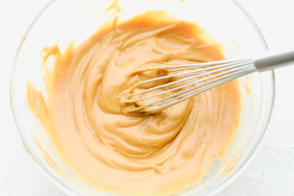Add a hint of delicious Thai cuisine with this super easy sauce that is the perfect blend of savory and sweet. Peanut Sauce is so addictive- you will want to put it on everything! Whisking Peanut Sauce ingredients together.