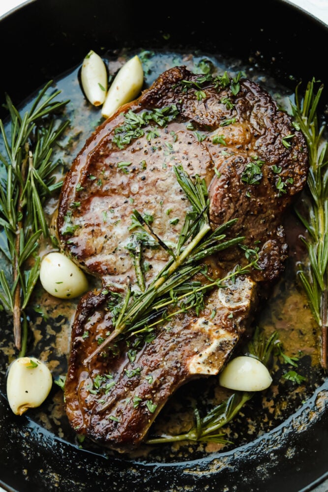 Achieving steakhouse-worthy flavors doesnโt have to be difficult! The ultimate ribeye steak is juicy, flavorful, and seared to perfection all in the comfort of your kitchen. Cooked ribeye steak garnished with rosemary, thyme, and garlic.
