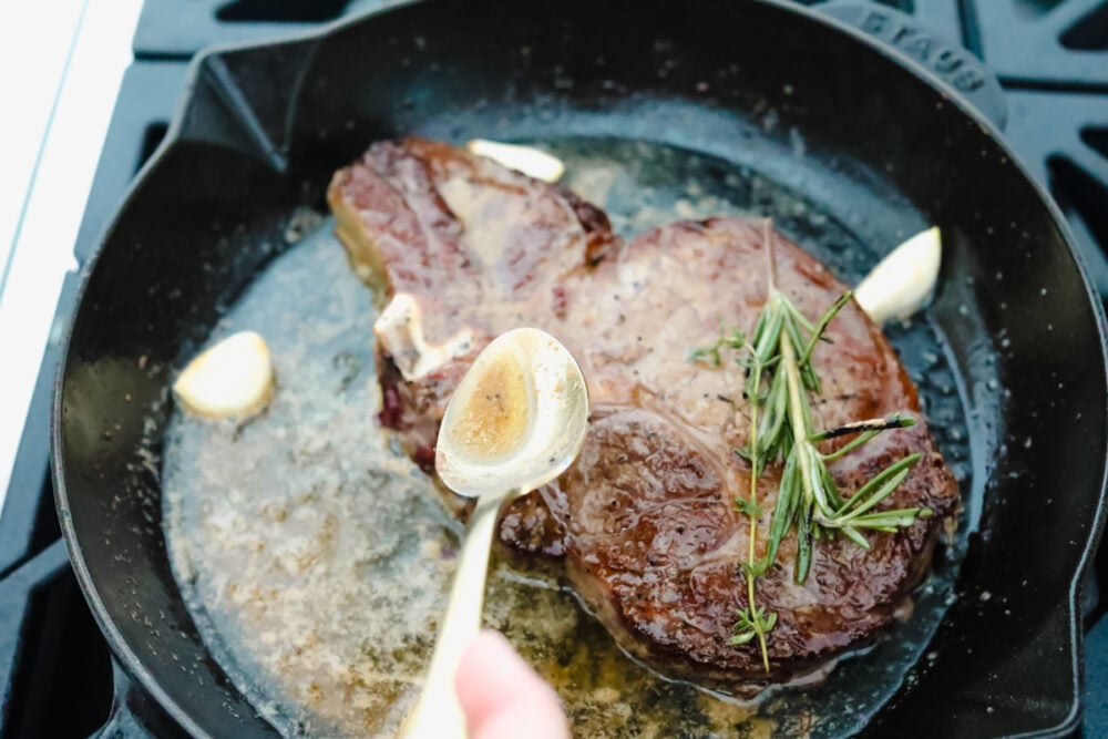 Achieving steakhouse-worthy flavors doesnโt have to be difficult! The ultimate ribeye steak is juicy, flavorful, and seared to perfection all in the comfort of your kitchen. Spooning butter over ribeye steak.