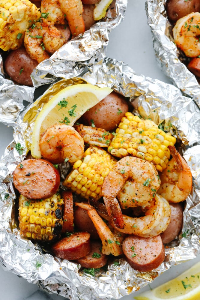 Shrimp Boil Foil Packets bring you juicy, tender shrimp and veggies tossed in Cajun spices! These pack all the kick and amazing flavor of Cajun cooking without the mess! Cooked shrimp, sausage, and corn in a tin foil packet.