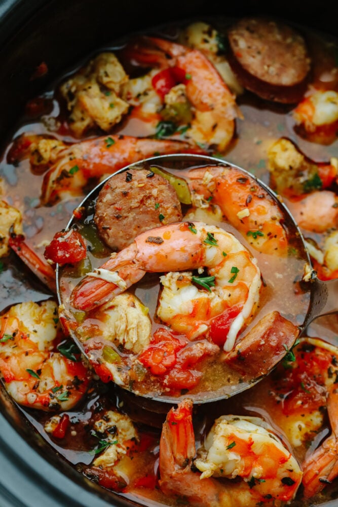 Slow Cooker Jambalaya is loaded with tasty sausage, chicken, and shrimp that gets cooked low and slow to activate the bold spices. This hearty dinner is an effortless meal that is ready with only 10 minutes of prep! Scooping up shrimp and sausage in jambalaya.