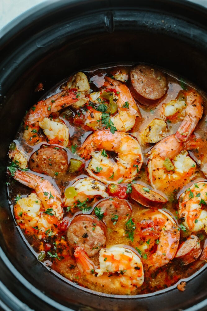 Slow Cooker Jambalaya is loaded with tasty sausage, chicken, and shrimp that gets cooked low and slow to activate the bold spices. This hearty dinner is an effortless meal that is ready with only 10 minutes of prep! Seafood and sausage cooking in a slow cooker.