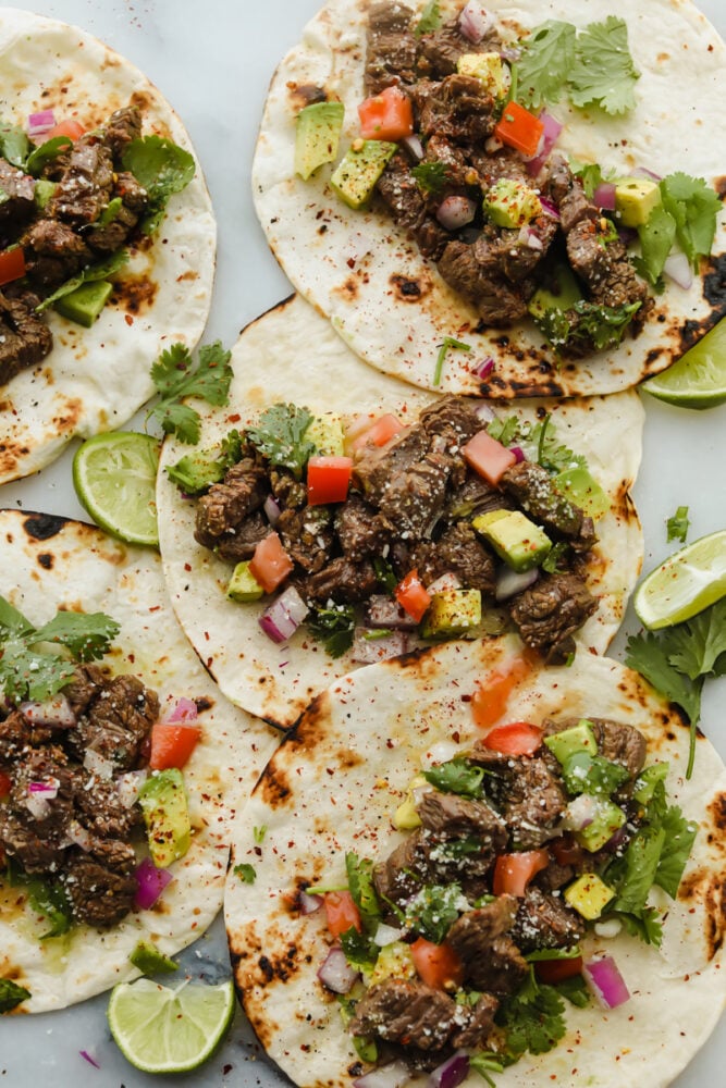 Street Tacos. Delicious, amazing, mouthwatering street tacos. I cannot stop thinking about these! They are SOO delicious. You will want to gobble these all up at once! Tortillas being topped with steak and taco toppings.