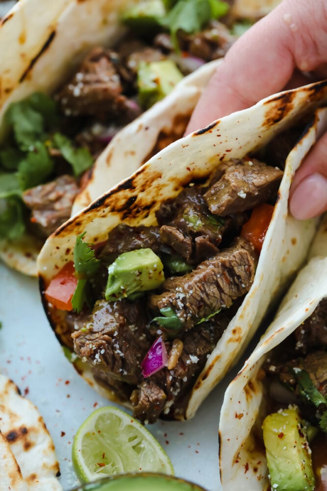 Street Tacos. Delicious, amazing, mouthwatering street tacos. I cannot stop thinking about these! They are SOO delicious. You will want to gobble these all up at once! A taco folded up being held and ready to eat.