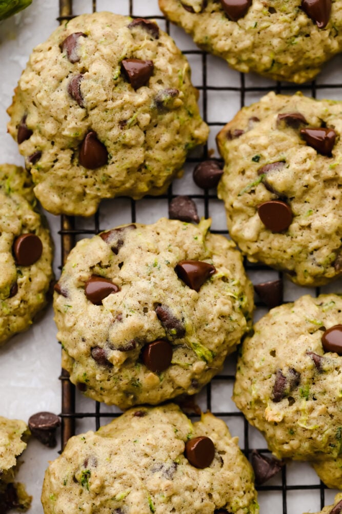 These zucchini oat chocolate chip cookies are a twist on the traditional cookie recipe and are absolutely delicious! Cookies are the ultimate comfort food that we all love and adore and after trying these, I bet you won't be able to just have one!! Zoomed in photo of a finished zucchini oat chocolate chip cookie.