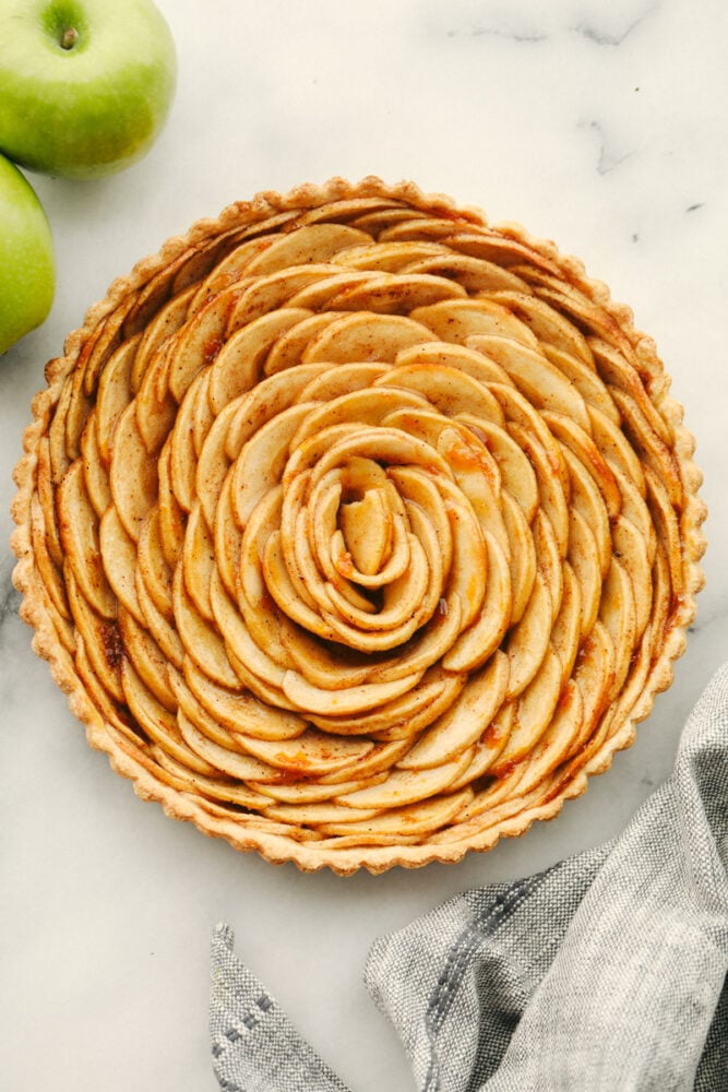 Loaded with fresh apples and baked to a perfect golden brown, this beautiful apple tart is the pastry of the summer! A combination of buttery, nutty, and tart, it tastes as good as it looks! A whole tart, baked.