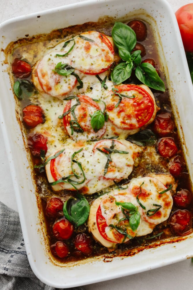Baked Caprese chicken is nothing less than delicious and delightful! It's fancy enough for company but simple enough for a quick and easy weeknight dinner that your family will go crazy for! Baked chicken in casserole dish.