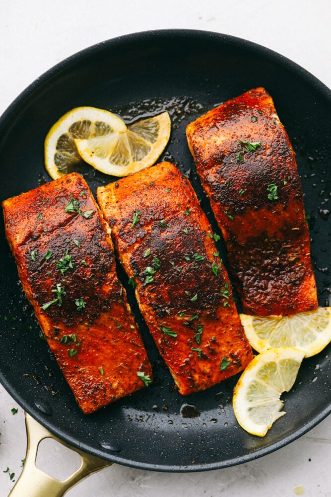 Easy and Amazing Blackened Salmon is a foolproof way to cook restaurant-worthy salmon at home! The salmon is tender and flakey and packed with flavor that is going to wow your taste buds! Slices of lemon garnish fillets of blackened salmon.