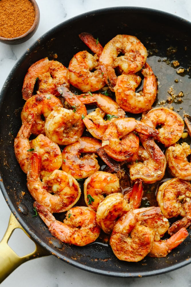 Cajun shrimp that is insanely delicious and only takes 5 minutes to make is the kind of dinner that dreams are made of! This recipe will knock your socks off and it will be something that the whole family will go crazy over! Cajun shrimp cooking in a pan.