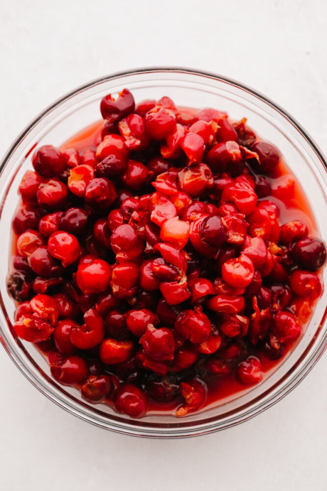 This cherry pie filling comes together so quickly and will make enough for you to have on hand for pies all year!! Delectable and sweet with a hint of tartness, this filling is perfection and you won't be able to go back to store-bought ever again!! Cherries mixed in a bowl.