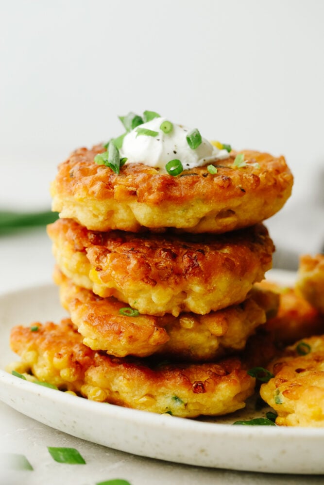 Corn Fritters are the best combination of savory tastes that are cooked to golden brown perfection! Crispy on the outside with a soft and tender inside, these are insanely delicious! A stack of corn fritters.