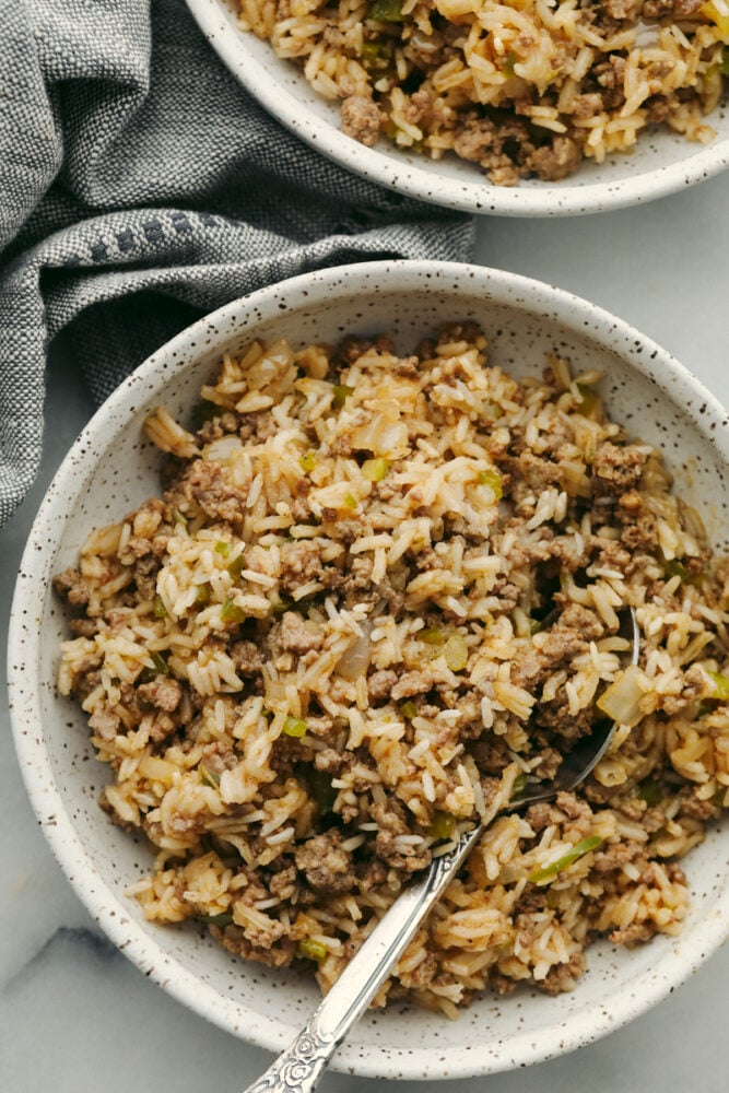 Why is it called โdirtyโ rice? The rice gets brown as it cooks with meat, Cajun spices, and the holy trinity of Cajun cooking: onion, bell pepper, and celery. My version combines ground pork and beef for a flavorful twist on this Louisiana classic! Dirty rice in a bowl with a spoon.