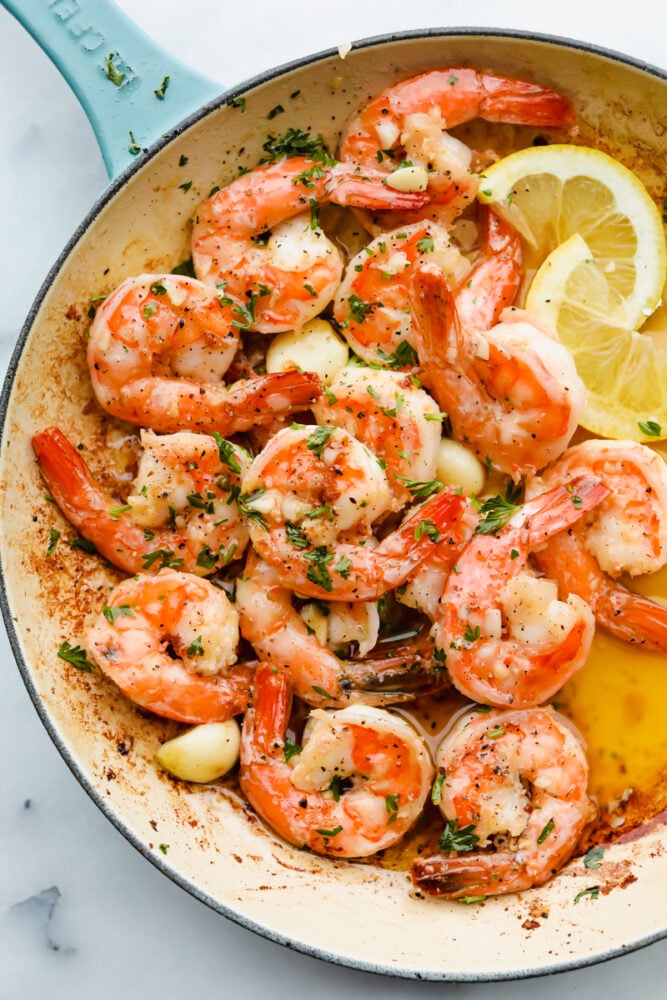 Garlic, butter, and shrimp. It doesn't get much tastier than those three ingredients! Combine them together and you will have a melt in your mouth, smack your lips kind of food that you will go back to over and over again! Cooked shrimp with garnish in a dish.