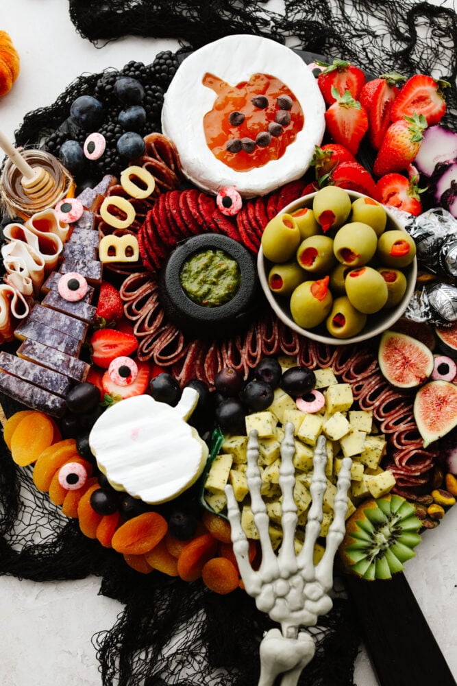 This Halloween charcuterie board is a ghoulish treat for any party! A spooky twist on your classic cheese board, it's filled with fruit, crackers, and meat and sure to be everyone's favorite! A Halloween charcuterie board.