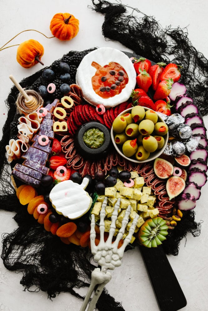 This Halloween charcuterie board is a ghoulish treat for any party! A spooky twist on your classic cheese board, it's filled with fruit, crackers, and meat and sure to be everyone's favorite! Halloween charcuterie board.