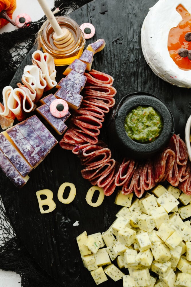 This Halloween charcuterie board is a ghoulish treat for any party! A spooky twist on your classic cheese board, it's filled with fruit, crackers, and meat and sure to be everyone's favorite! Meat on a charcuterie board.