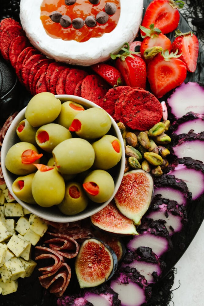 This Halloween charcuterie board is a ghoulish treat for any party! A spooky twist on your classic cheese board, it's filled with fruit, crackers, and meat and sure to be everyone's favorite! Zoomed in picture of a charcuterie board.