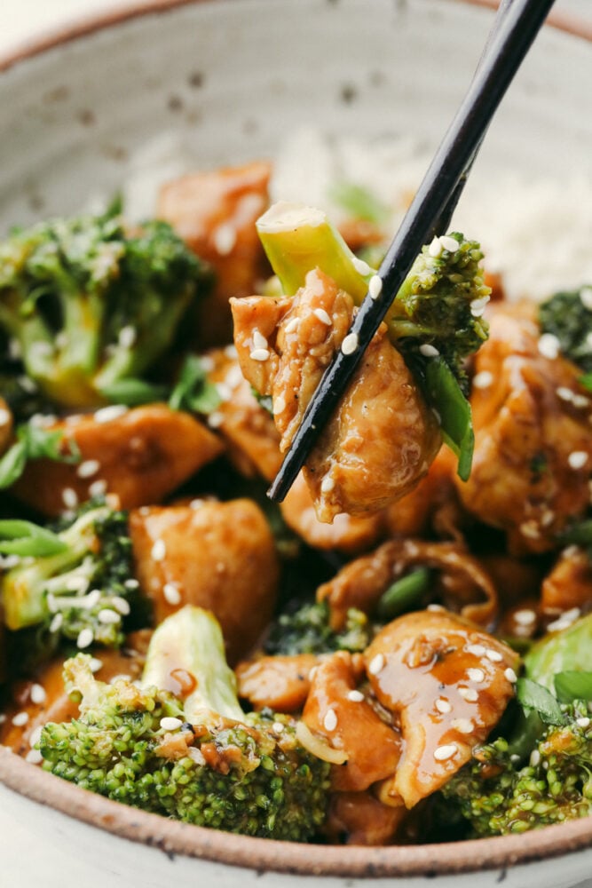 Stir-fried chicken and broccoli are topped with a mouthwatering Hoisin sauce glaze in this super easy recipe. Loaded with amazing Cantonese flavor, hoisin chicken is going to become a new regular in your dinner rotation! Taking a bite of hoisin chicken with chopsticks.