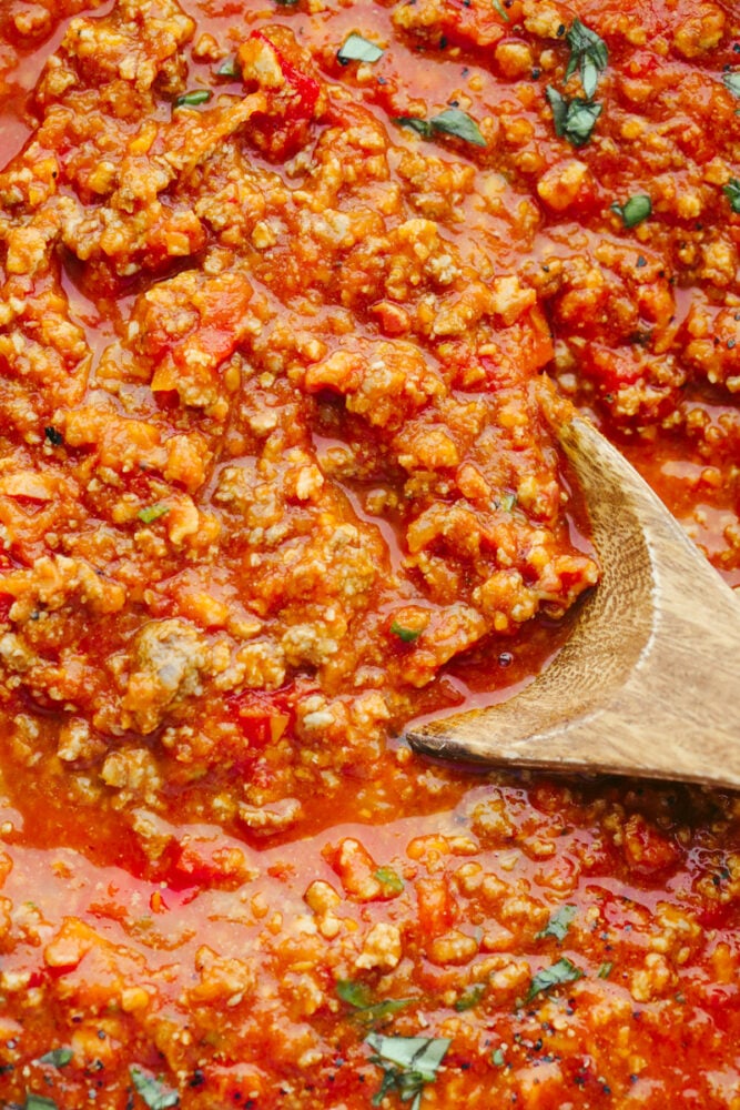 Bolognese sauce is heavenly and boy is the texture is something to write home about! With some love and patience, this sauce will turn out to be a work of art and TOTALLY worth the time you put into it!! Zoomed in picture of the sauce with a wooden spoon in it.