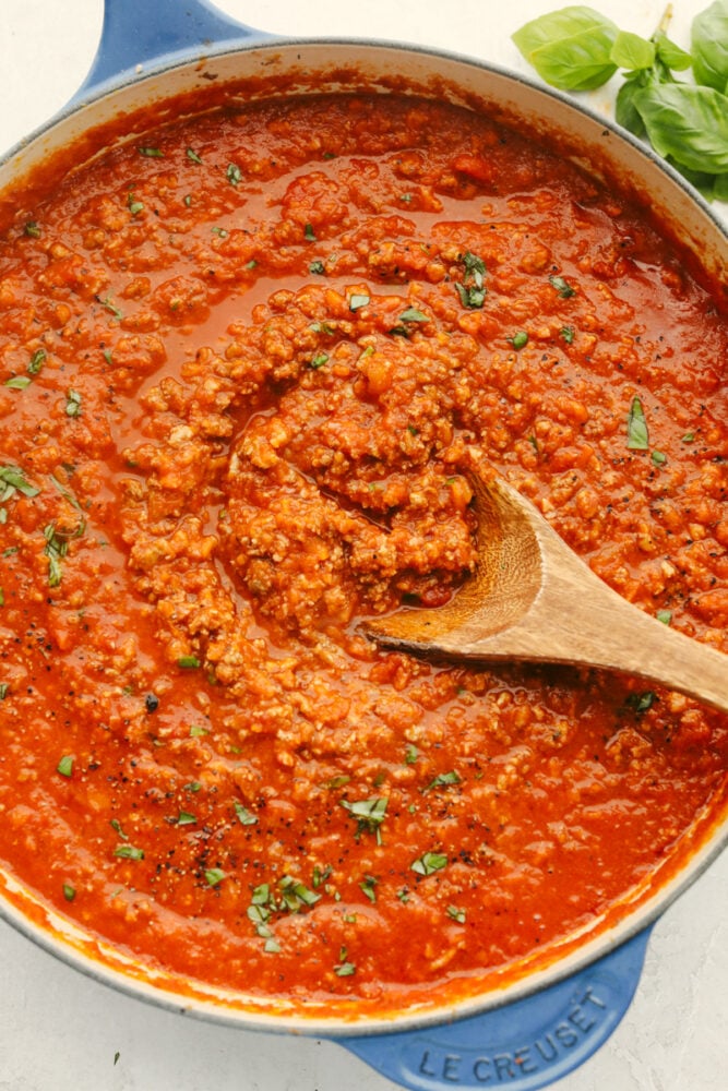 Bolognese sauce is heavenly and boy is the texture is something to write home about! With some love and patience, this sauce will turn out to be a work of art and TOTALLY worth the time you put into it!! Bolognese sauce with a wooden spoon.