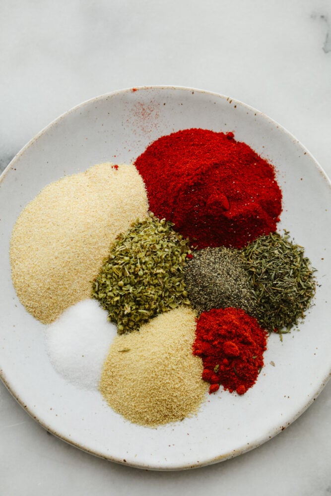 Cajun seasoning is the perfect blend of spices to add a little zest to your dish. Completely versatile and delicious, this homemade spice can be added to a wide variety of recipes giving them just the yummy kick you were looking for! Spices ready to be mixed together in a bowl.