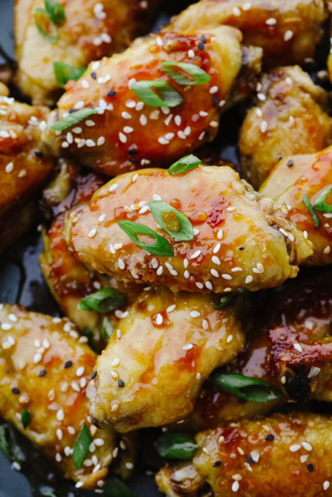 Sticky honey garlic wings are incredibly delicious and an excellent appetizer for absolutely any event or party! They have a mouthwatering, sweet taste that will keep you snacking all night long! Close up of sticky honey garlic wings.