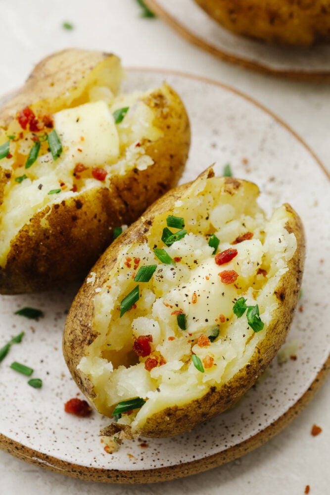 Using an Instant Pot is the best way to achieve the perfect baked potato every time! You are going to love how fluffy, golden, and easy to make these Instant Pot baked potatoes are! Baked potatoes topped with butter, chives, and bacon bits.