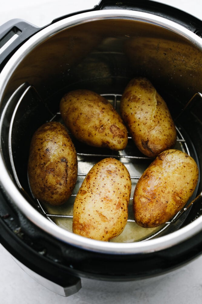 Using an Instant Pot is the best way to achieve the perfect baked potato every time! You are going to love how fluffy, golden, and easy to make these Instant Pot baked potatoes are! 5 baked potatoes in an Instant Pot.