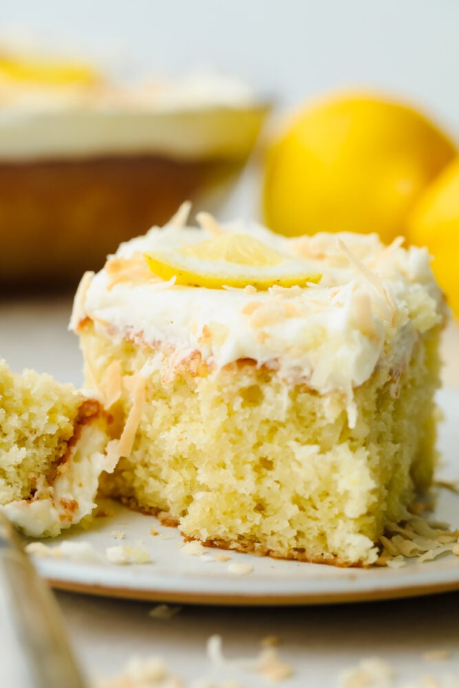 Lemon coconut cake is the perfect combination of delicious flavors and a soft texture! Moist and topped with the flaked coconut, this cake is insanely delicious and SOO good! A slice of lemon coconut cake.