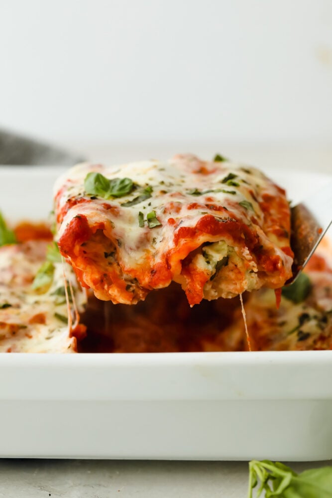 This manicotti is filled with 3 kinds of cheese and baked to absolute perfection! It's comfort food at its finest that everyone will go crazy over! It's definitely sure to please a large crowd! Close up of manicotti being served.