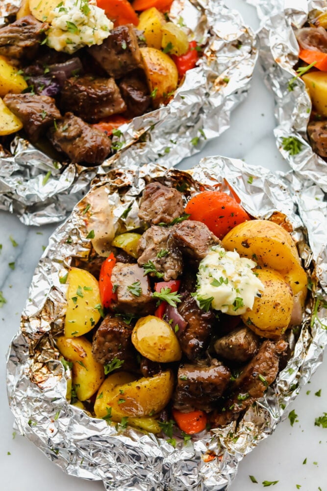 Butter Garlic Herb Steak Foil Packets have melt in your mouth beef with hearty veggies that are grilled to perfection with butter that has garlic and herbs inside. This is one amazing meal that you don't want to miss out on! Steak and vegetables wrapped in foil.