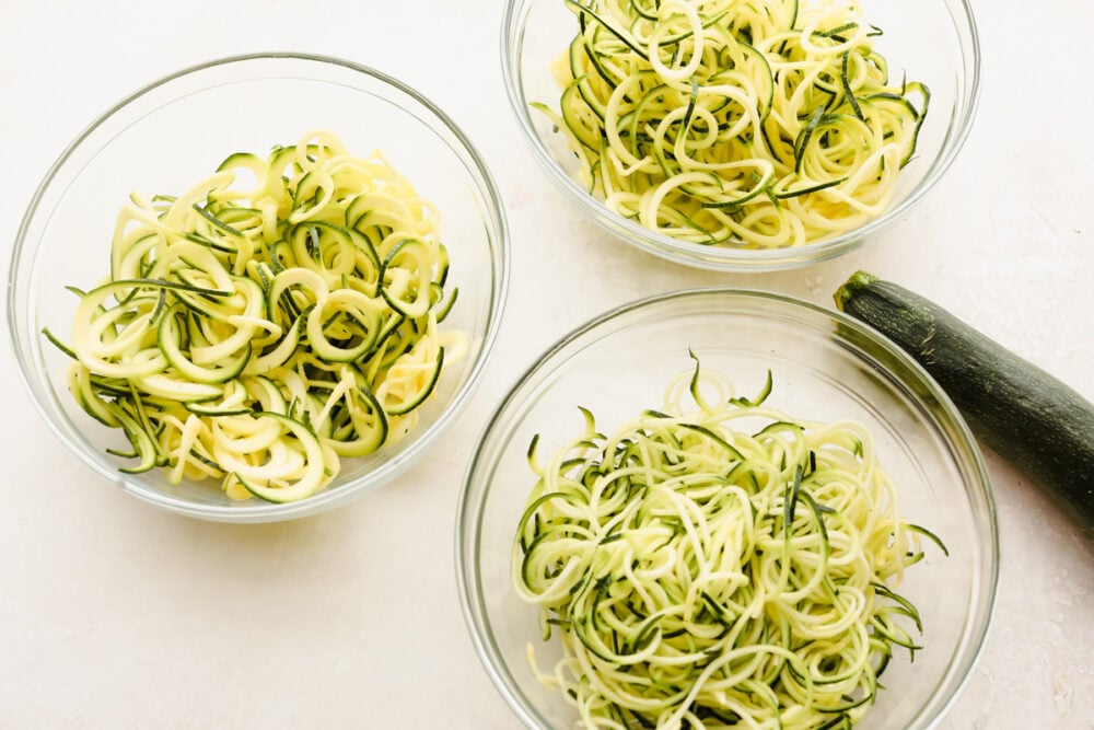 Zucchini noodles are the perfect low-carb option for pasta night. Use these 3 cooking methods to add a little healthy goodness to dinnertime! 3 bowls of zucchini noodles.