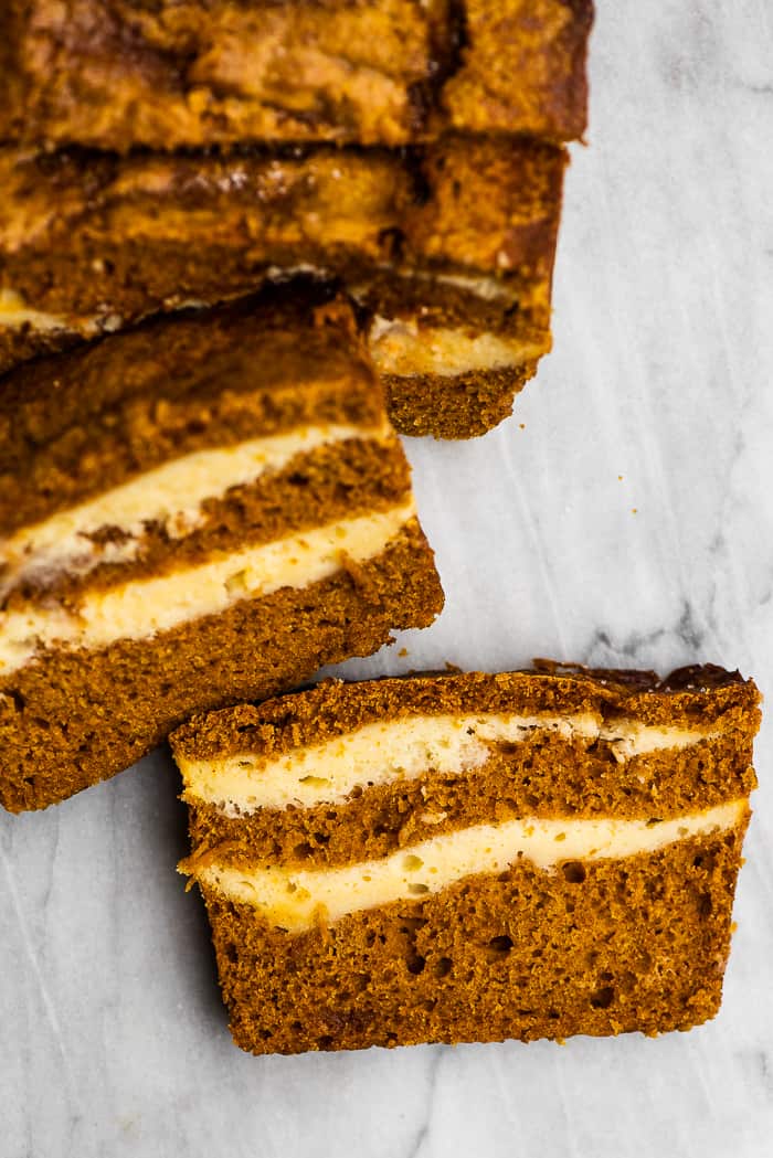 This cream cheese pumpkin bread recipe is truly the best ever. The moist and tender pumpkin bread is swirled with cream cheese frosting that's baked right into the loaf. It makes the perfect fall treat! pumpkin cream cheese bread sliced.