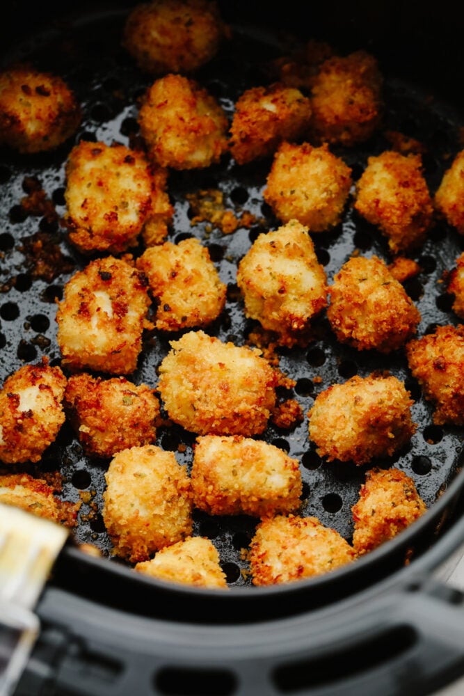 Air fryer chicken nuggets are absolute perfection! They are crispy on the outside, tender on the inside, and are just waiting to be dipped in any of your favorite sauces! Your family will go crazy over them! Chicken nuggets cooking in an air fryer.