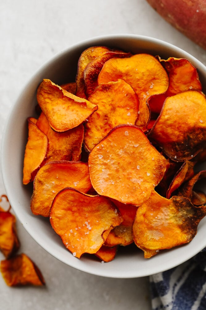 Air fryer sweet potato chips are the most delicious, crunchy snack! They are SOO good and much healthier than the store-bought version! This homemade favorite is something you can munch on all day long! Air fryer sweet potato chips in a bowl.