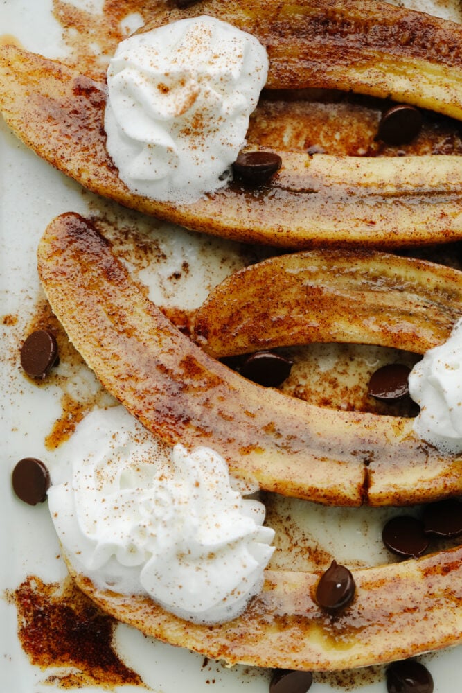 Baked bananas are deliciously sweet with a touch of cinnamon and honey! They are baked to perfection and I love nothing more than a dessert that's easy AND made with fruit! Zoomed in picture of sliced, baked bananas.