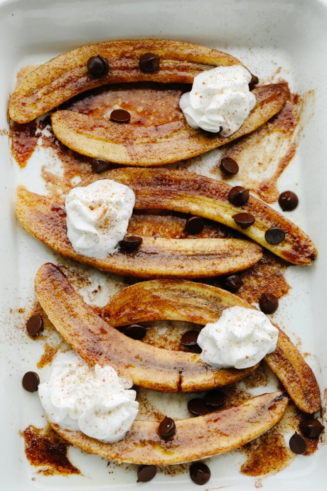 Baked bananas are deliciously sweet with a touch of cinnamon and honey! They are baked to perfection and I love nothing more than a dessert that's easy AND made with fruit! Sliced, baked bananas with toppings.