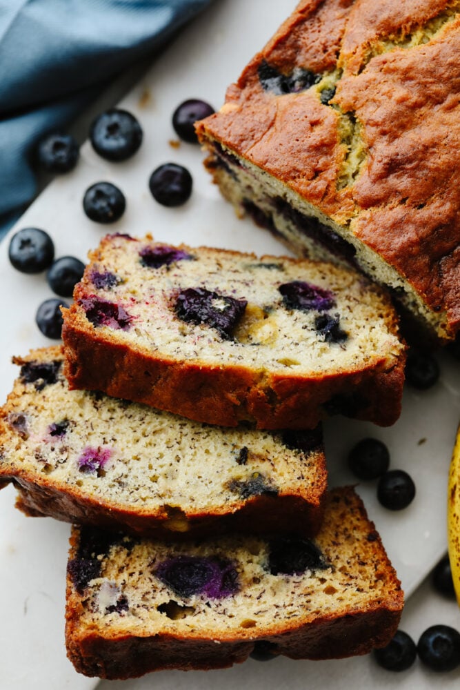 This staple blueberry banana bread recipe has the perfect combination of bananas and fresh blueberries. It is so moist, delicious, andย super simple to make! 3 slices cut from a loaf of banana bread.