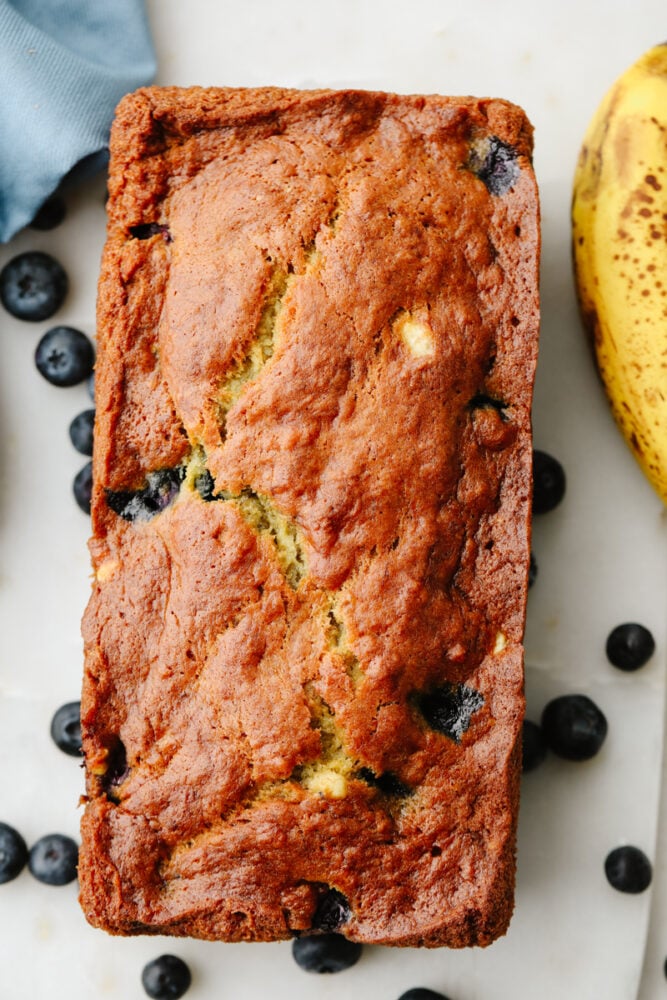 This staple blueberry banana bread recipe has the perfect combination of bananas and fresh blueberries. It is so moist, delicious, andย super simple to make! A loaf of blueberry banana bread.