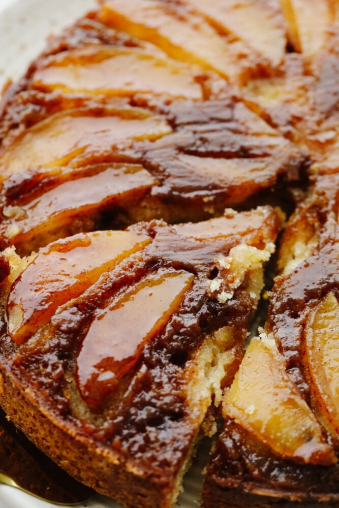 Caramel apple upside-down cake is just the dessert you need for fall! It's rich, moist, and smothered in a scrumptious caramel glaze! Close-up of a slice of apple cake with caramel glaze.