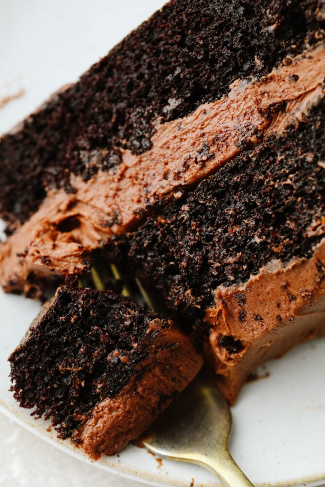 Chocolate cake is a classic, must-have recipe for every occasion! It is moist and delectable and the chocolate flavor is absolutely incredible! A slice of chocolate cake being cut with fork.